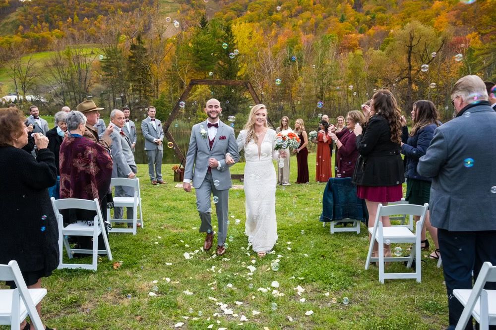 A couple being showered in bubbles after getting married outside in the Fall at Catamount Resort